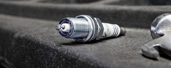 What is the function of a spark plug on a motorcycle?