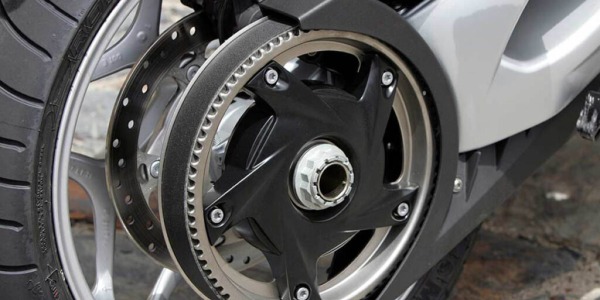 What advantages does the transmission in motorcycles with a toothed belt have?